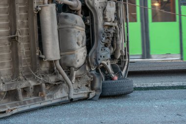 Ters dönmüş bir araba minibüsü yolda yan yatarken, arabanın dibi kameraya bakar. Alt ters dönmüş araba minibüsü yakın plan.