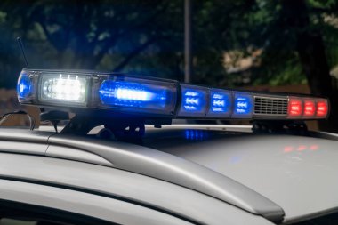 Polis açık havada arabanın tavanının ışıklarını dağların arka planına doğru kırpıyor. Teşhirci ve antenli en iyi devriye arabası. Devriye arabası yanıyor. Kapat