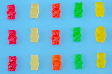 Mavi bir zemin üzerinde nefis parlak jöle ayılar aynı sırayla serilmiş, üst görünüm