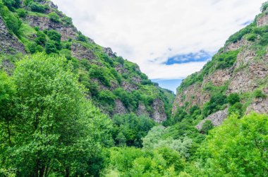 Vardzia mağara manastırının panoramik manzarası. Manastırdan nehir vadisine ve güneşli bir yaz gününde yeşil yamaçlara bakın.