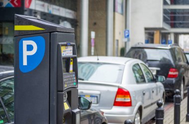 Sokakta park sayacı var. Park alanlarında arabaları olan bilet ödeme istasyonu..