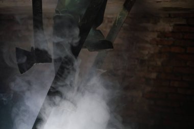 Baltalı bir adam karanlık bir bodrumda merdivenleri tırmanıyor.