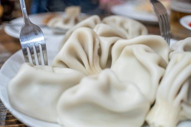Geleneksel Gürcistan mutfağı Khinkali çatalla tabakta, üst manzara yakın
