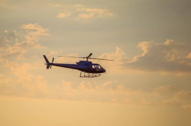 Gün batımında gökyüzünde bir helikopter görüntüsü