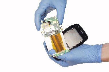 Kırık telefonu tutan mavi eldivenli beyaz bir arka plan. 