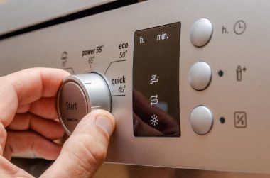 Adamın eli şık siyah bulaşık makinesi kontrol panelinde.