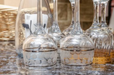 Arka plandaki hasır sepetin yakınındaki masada ters çevrilmiş bardaklar.