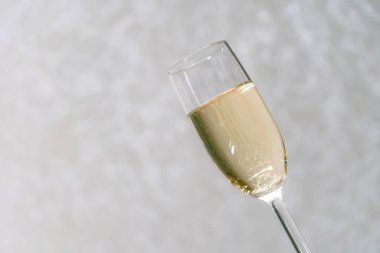 Şampanya kadehi ışık arkaplanına yakın eğik ve fotokopi alanı var.