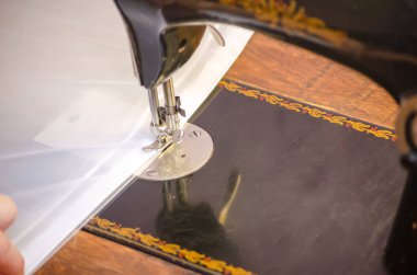 Dikiş makinesine dikiş dikmek. Dikiş makinesinde beyaz kumaş