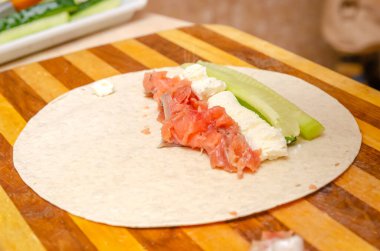 Tortilla rulo somon, taze peynir, marul ve taze salatalık pişirme süreci.