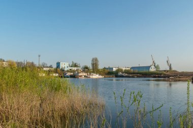 Eski rıhtım, demirli eski gemiler ve yatlar, kıyıdan gelen martılar. Bahar, güneşli hava.