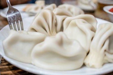 Geleneksel Gürcistan mutfağı Khinkali çatalla tabakta, üst manzara yakın