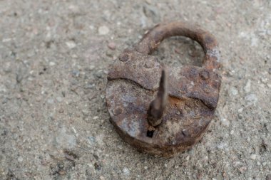Paslı metal kilit beton zemine yakın.
