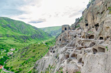 Mağara şehri Vardzia 'nın manzarası. Mağara şehrinden nehir vadisine ve güneşli bir yaz gününde yeşil yamaçlara bakın.