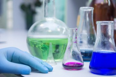 Masa kimyasallar ve mataralarla dolu. Kimya laboratuvarı. Eller