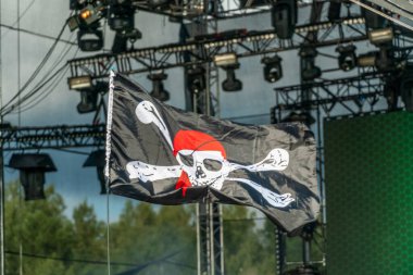 Jolly Roger. Işıklandırma ekipmanının arka planında korsan bayrağı var. Korsanların sembolü. Konserde korsan bayrağı
