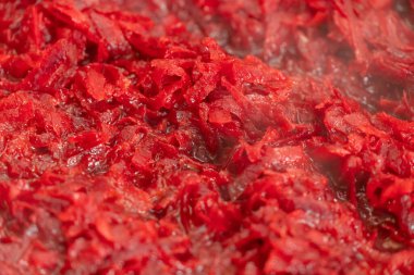 Çiğ rendelenmiş pancarlar bir tavada, buharda, arka planda pişirildi