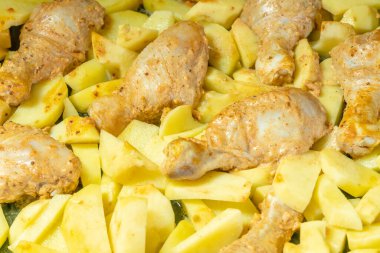 Patates dilimli tavuk bacağı fırının yakın çekiminden fırında pişirilir..