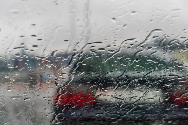 雨は雨の日に車のガラスに降り注ぎ — ストック写真