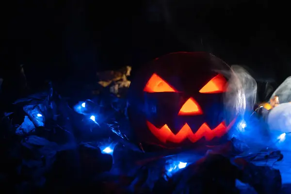 Светящаяся Тыква Темноте Голубыми Огнями Осенними Листьями Дыму Фоном Хэллоуина — стоковое фото