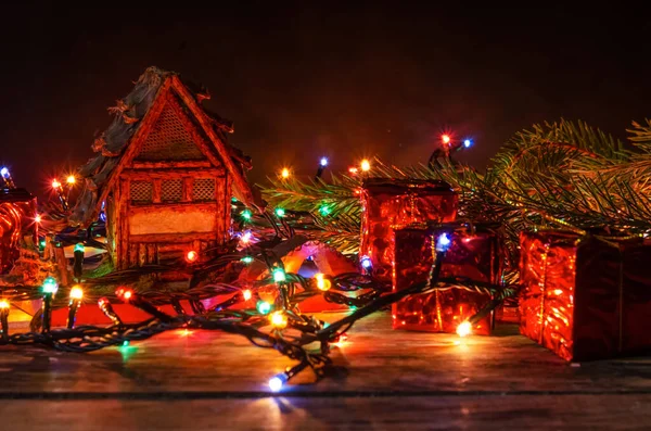 Speelgoedhuis Een Houten Achtergrond Verstrengeld Kerstslinger Zijn Kleine Geschenken Takken — Stockfoto