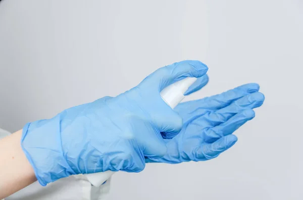 Доктор Белом Халате Голубых Перчатках Дезинфицирует Руки Антисептическим Спреем Вблизи — стоковое фото