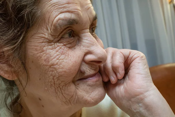 Portrait of a happy smiling elderly woman with a mole above her lip