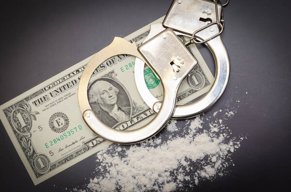 Handcuffs, money and cocaine drugs on black background close up