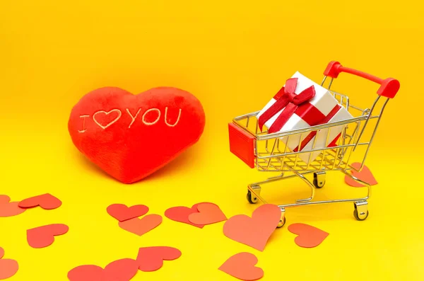 Geschenkkarton Warenkorb Auf Gelbem Hintergrund Neben Roten Herzen Kopierraum Konzept — Stockfoto