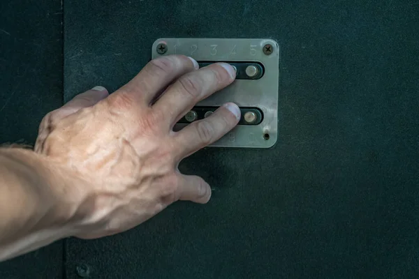 man\'s hand dials the code from the door intercom close up