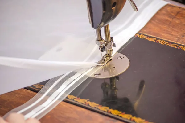 sewing on a sewing machine. white fabric on sewing machine