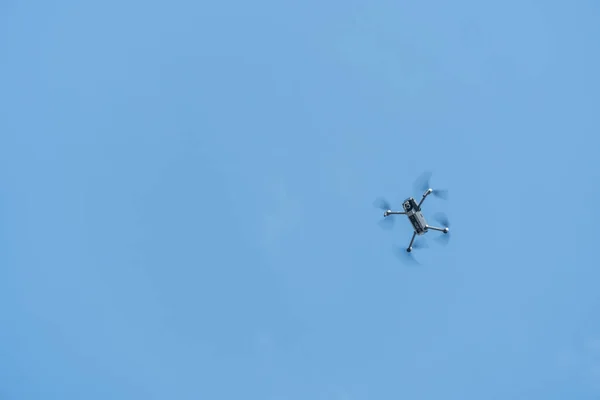 Professionell gefilmte Drohnen fliegen in niedriger Höhe vor blauem Himmel in die Luft. Drohne macht Fotos. Moderne neue Technologie — Stockbild Professionell Gefilmte Drohnen Fliegen Niedriger Höhe Vor Blauem Himmel Die — Stockfoto