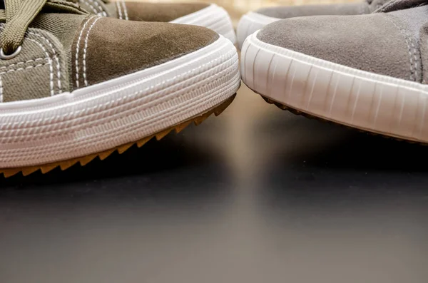 Een Paar Donkergroene Sneakers Voor Een Paar Grijze Sneakers Close — Stockfoto