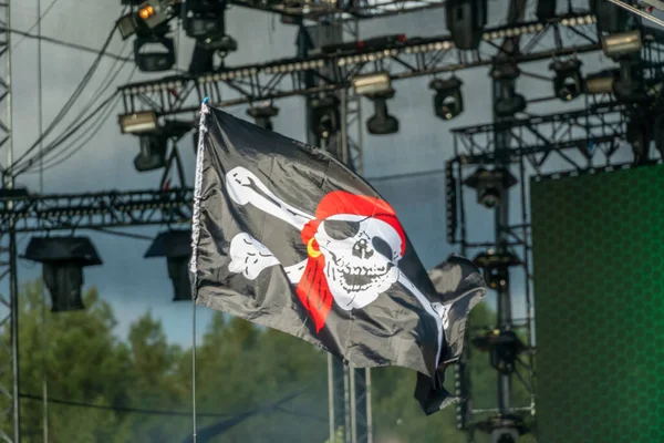 jolly Roger. Pirate flag close-up on the background of lighting equipment. Symbol of pirates. Pirate flag at the concert