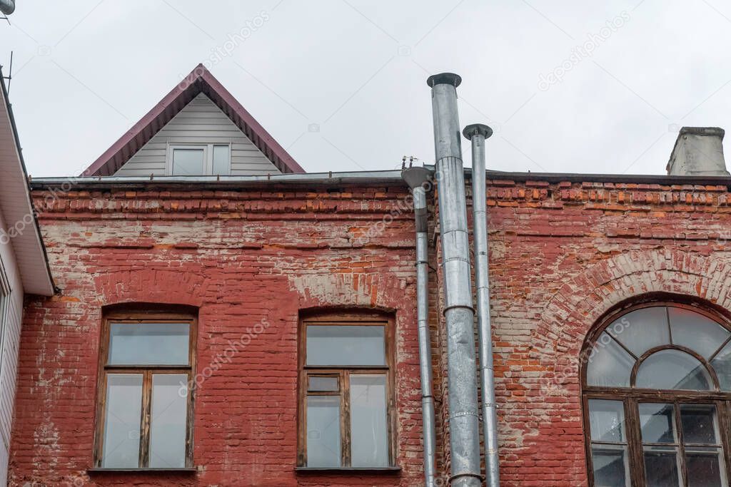 old red brick building with a rainwater drainage pipe