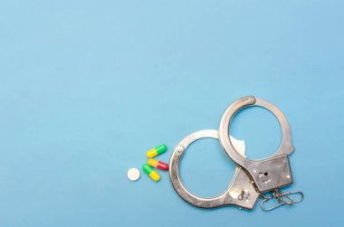 Kelepçe ve haplar mavi arka planda, boşluğun bir kopyası var.