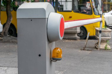Avluda gündüz saatlerinde otomatik kırmızı-beyaz bariyer var.