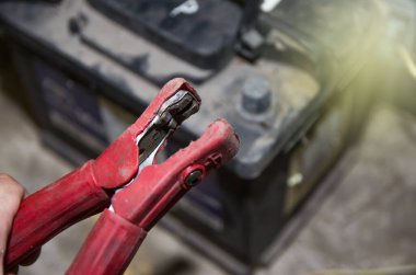 Elektriği şarj etmek için pozitif ve negatif terminaller kullanarak arabanın aküsünü maşayla kontrol et.