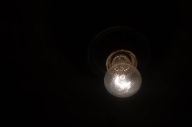 Siyah arkaplanda parlayan ampul, boşluğu kopyala