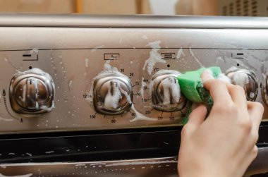 Kadının eli yeşil bir süngeri gri paslanmaz çelik gaz sobasının düğme kolunda köpükle yıkıyor. Daireyi temizliyorum.