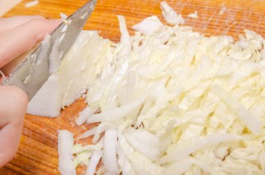 Bıçaklı kadın eli Pekin lahanası açık yeşili. Sebze salatası, yan manzara.