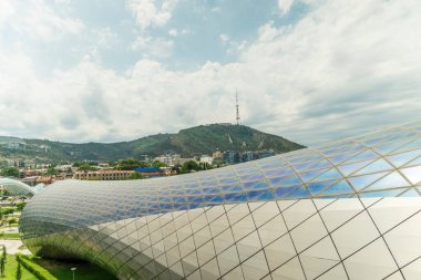 Güneşli bir günde, Tiflis, Georgia 'daki Rick Park' taki modern bir kültür kompleksinin yan görüntüsü
