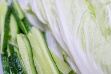 Taze salatalık dilimlenmiş ve kapta Pekin lahana yaprakları var.