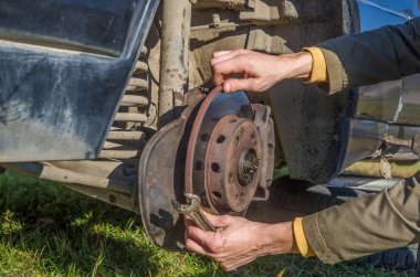 Arabanın ön tekerleğini kapat ve çimento yolundaki tamir hizmeti konseptini kaldır.