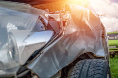 Araba kazası ya da kaza. Gri arabanın sol farları kırık. Arabanın kırık parçaları, yakın plan. Aydınlatma ile fotoğraf