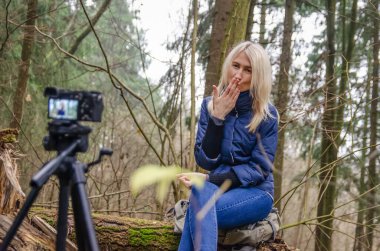 Fotoğrafçının ormanda genç bir kızla fotoğraf çekerken görüntüsü.