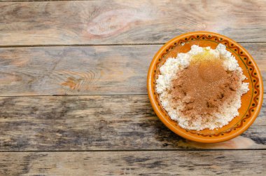 Kahverengi kasede kırılmış yumurta ve tarçınlı süzme peynir.