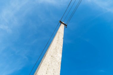 Parlak mavi gökyüzüne karşı yatay olarak uzanan kablolu bir direk. Resimde kopyalama alanı var. fotoğraf görünümü aşağıdan