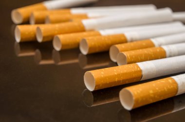 Siyah cam masaya saçılmış sigaralar.