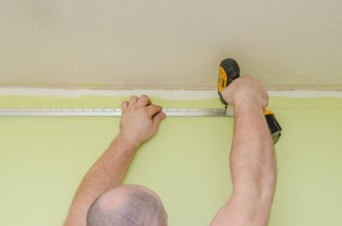 Gerilme tavanı için duvar rehberine bağlıyım. Tamirciler esnek bir tavan kurdular